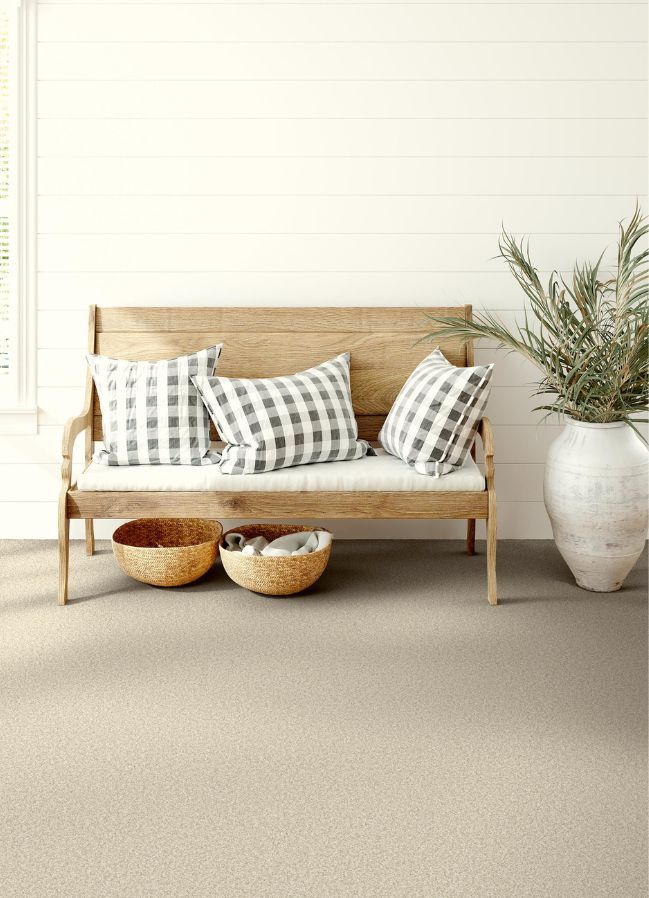 durable beige carpets in a bright entryway with stylish bench
